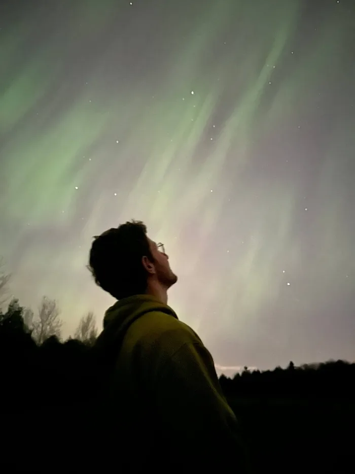 Quentin de espaldas bajo una aurora boreal