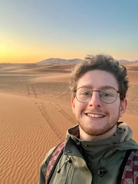 Quentin sonriendo en el desierto al atardecer